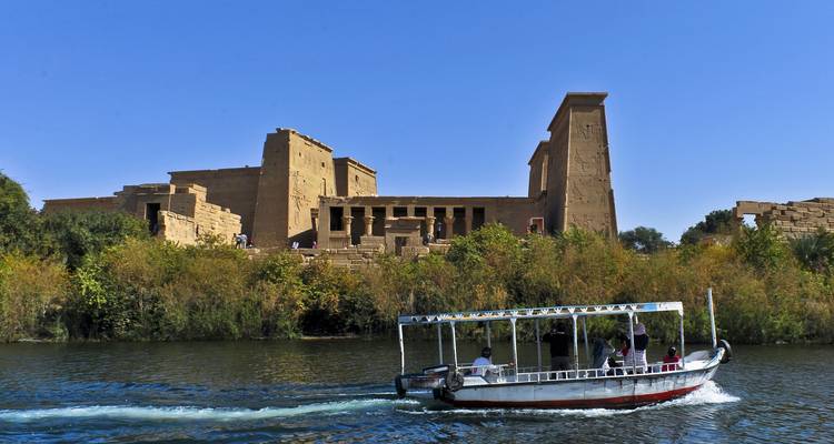 Ruinas de un templo junto al río con una pequeña embarcación.