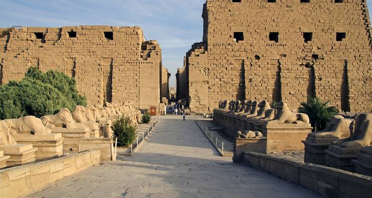 Imposing gateway with stone statues lining the path.