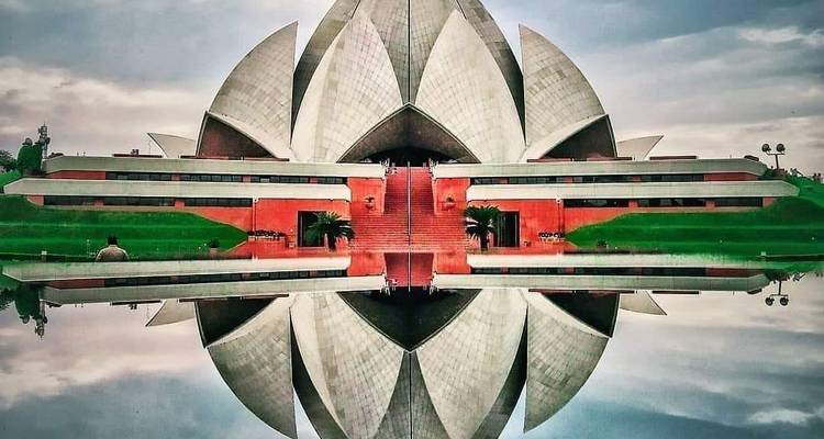 Lotus-Tempel, der sich an einem bewölkten Tag im Wasser spiegelt.