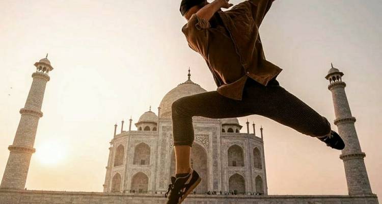 Persona saltando frente al Taj Mahal.