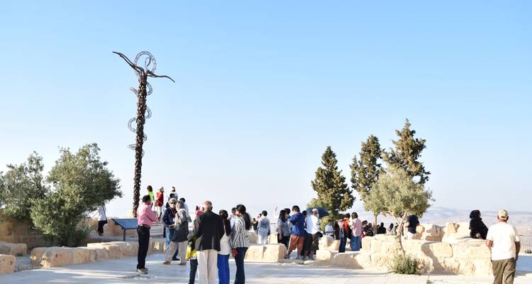 Un grupo de personas se reunió en un lugar al aire libre con esculturas.
