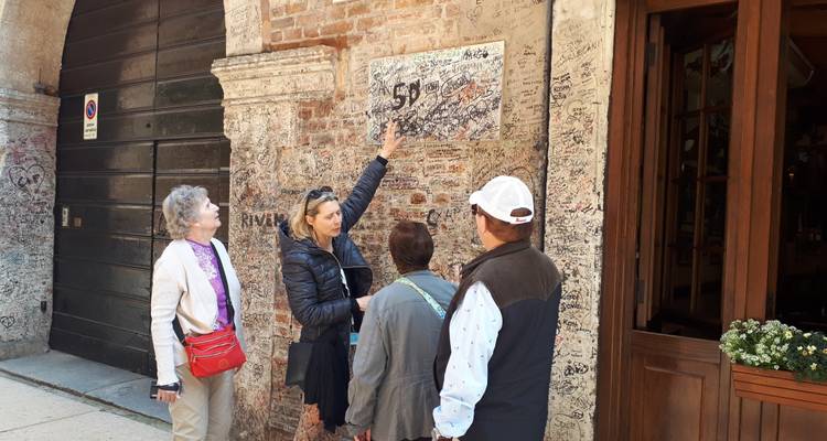 Groupe de touristes regardant un mur couvert de graffitis.
