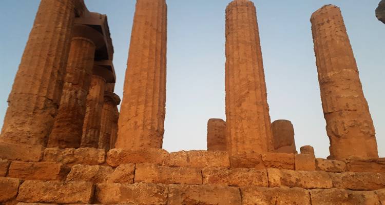 Alte Steinsäulen und Ruinen unter einem klaren Himmel.