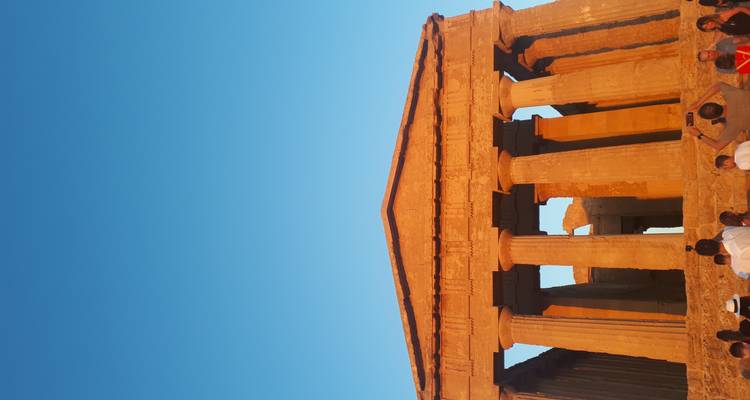 Nahaufnahme einer antiken Tempelfassade mit Besuchern.