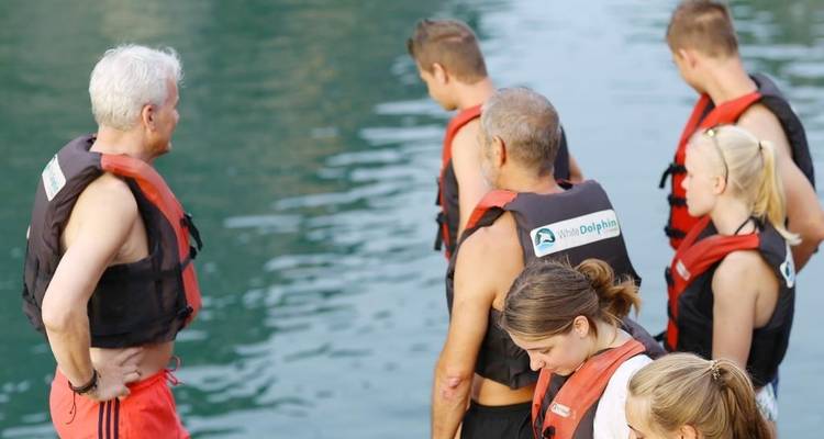 People in life vests preparing for a water activity.