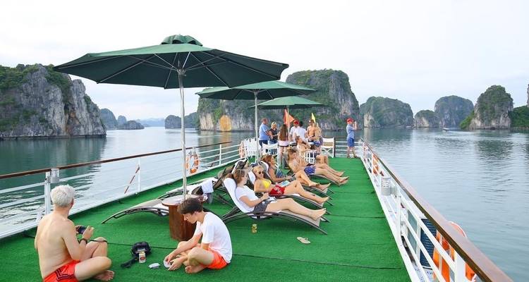 Group of people lounging on a boat deck with scenic views.