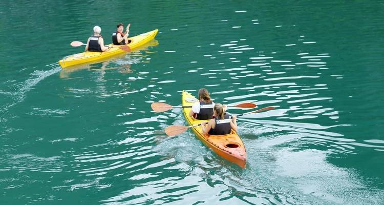 People kayaking on clear water.