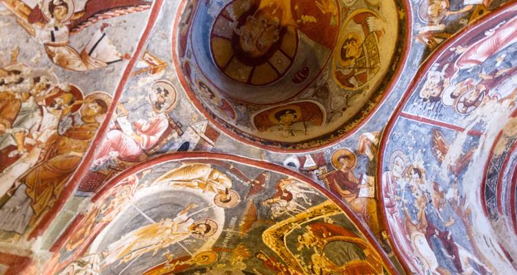 Kunstvolle religiöse Fresken an einer Kirchendecke.