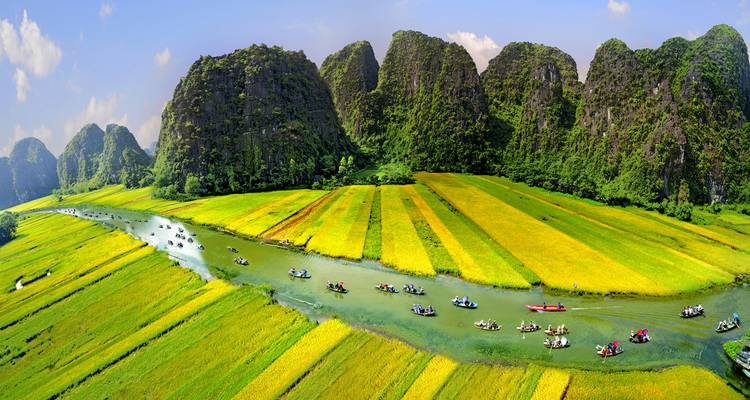Panoramisch uitzicht op de rivier met boten en kalkstenen heuvels.