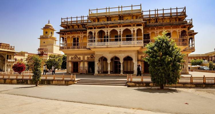 A luxurious palace surrounded by manicured gardens under a clear sky.