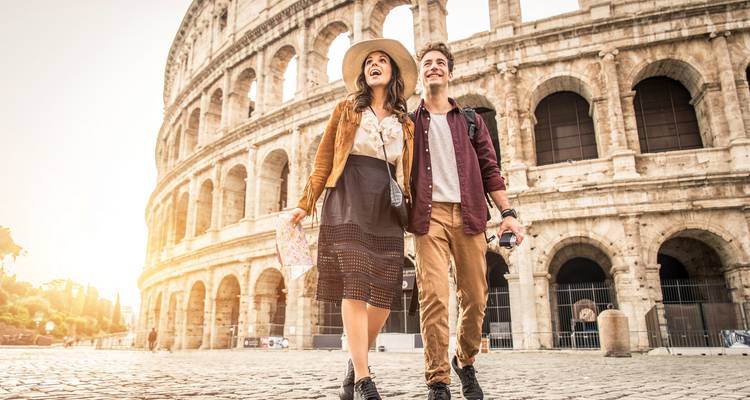 Couple walking by the Colosseum holding a map