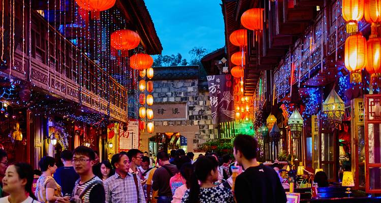 Crowded street with red lanterns and people enjoying the vibrant atmosphere.