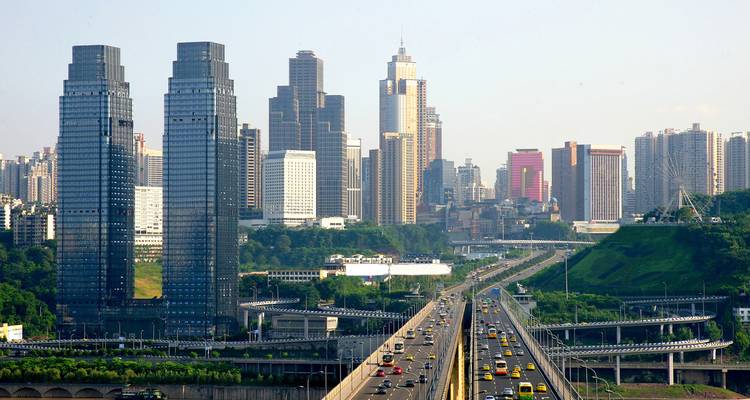 Urban skyline with modern skyscrapers and a busy highway.