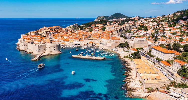 Stunning aerial of Dubrovnik's terracotta rooftops, city walls and sapphire Adriatic Sea.