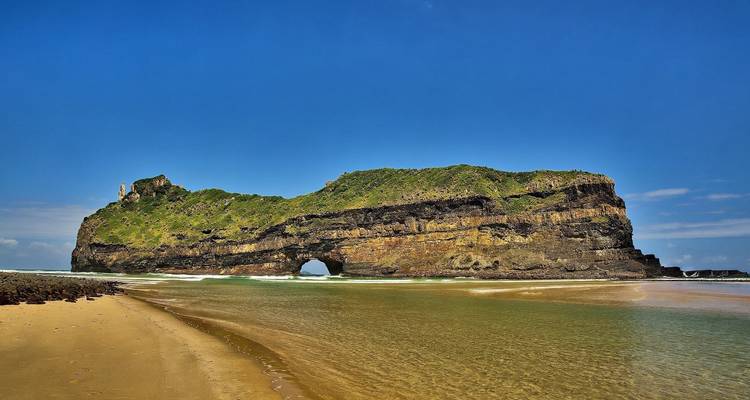Vista panorámica de la formación rocosa Hole in the Wall en la playa.