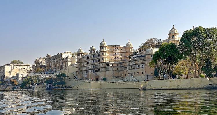 Un gran palacio junto a un lago, visto desde el agua.