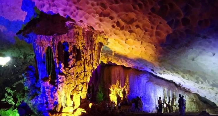 Interior de una cueva con iluminación colorida y formaciones rocosas.