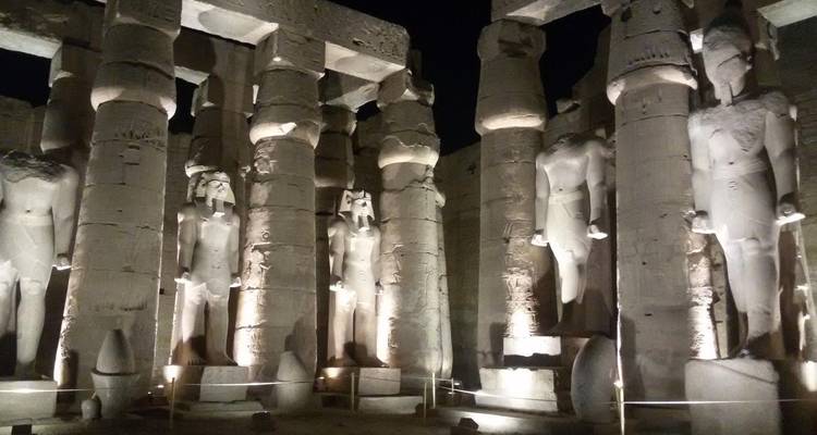 Antike Statuen nachts beleuchtet in einem Tempel.