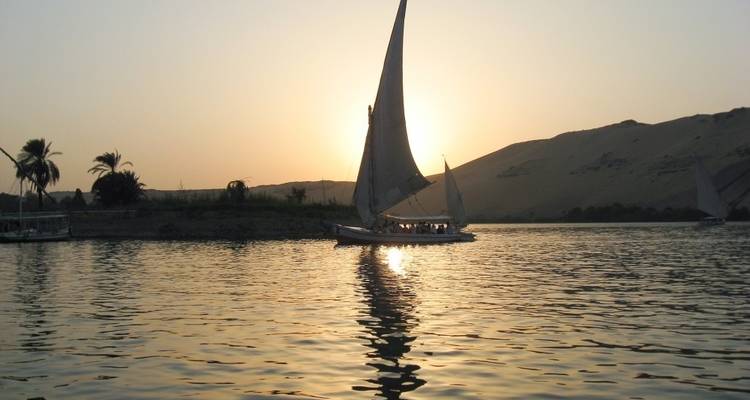 Sailboat on a river during sunset.