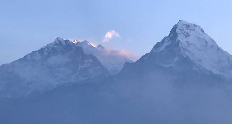 Bergtoppen bedekt met sneeuw bij zonsopgang.