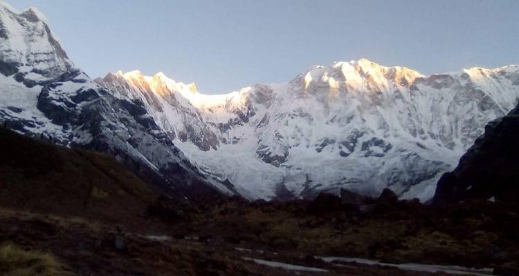 Besneeuwde bergen met zonlicht op de toppen.