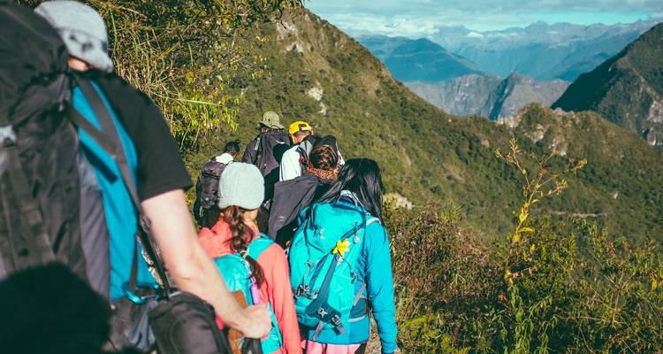 Groupe de randonneurs marchant sur un sentier de montagne.