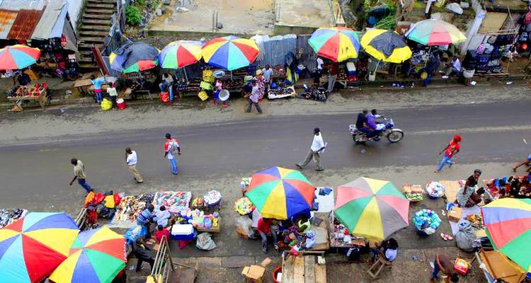 Un mercado callejero bullicioso con sombrillas coloridas.