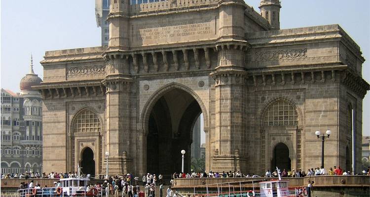 La Porte de l'Inde avec des gens et des ferries au premier plan.