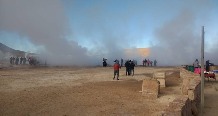 Visitantes en un paisaje lleno de vapor en campos de géiseres.