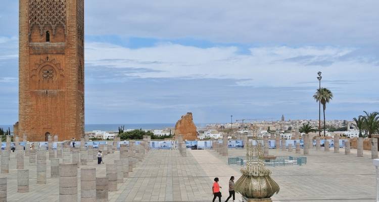 Ein Platz mit Hassan-Turm und gehenden Menschen.