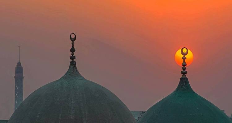 Sunset over domes with silhouettes of minarets