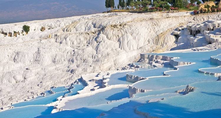 White terraces with blue mineral-rich pools and distant hills.