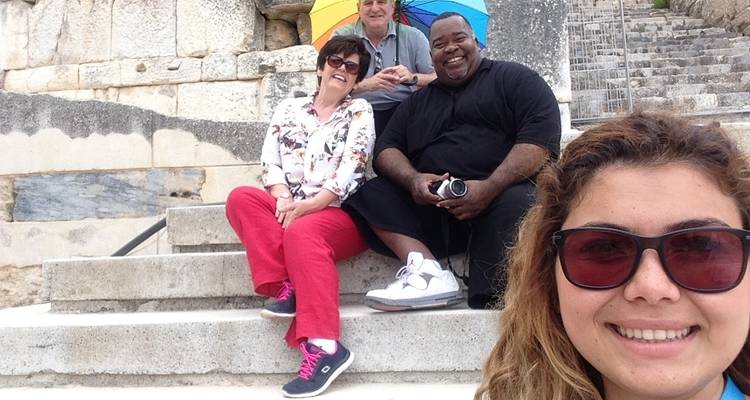 Des touristes assis sur les marches d'un site antique.
