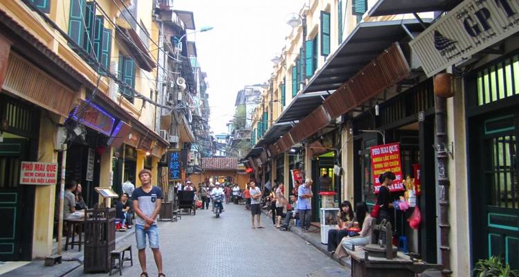 Une rue dans une zone urbaine bordée de magasins et de piétons.