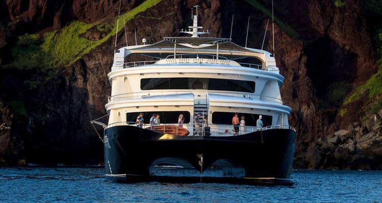Vista frontal de un gran crucero con personas en cubierta.