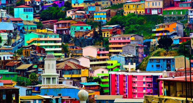 Barrio en ladera con colores vibrantes lleno de casas pintorescas y brillantemente pintadas.
