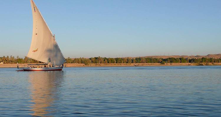 Traditionelles Felucca-Segelboot, das zur goldenen Stunde auf dem ruhigen Nil gleitet