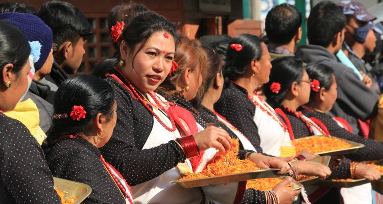 Las mujeres nepalíes ensartan guirnaldas de caléndulas brillantes durante una animada procesión festiva.