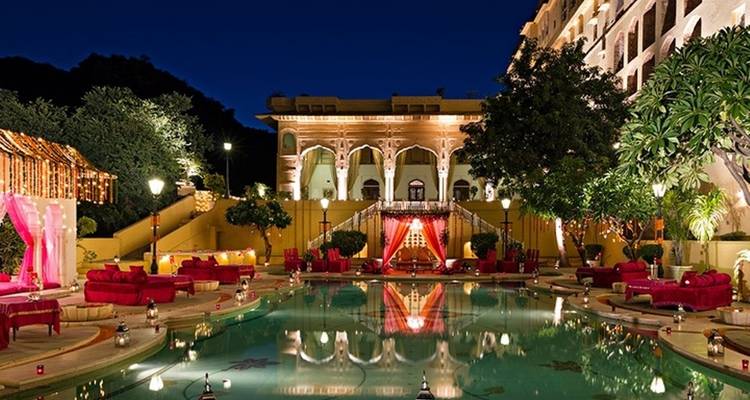 A luxurious courtyard with a pool at night.