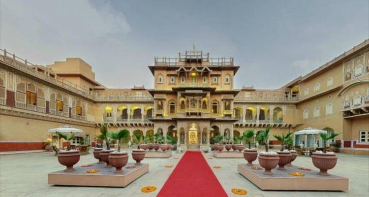 A grand courtyard with detailed architecture and red carpet.