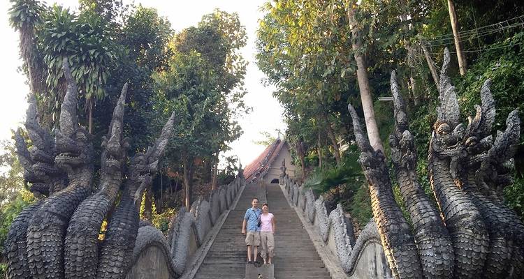 Des touristes sur un escalier avec des sculptures de dragons.