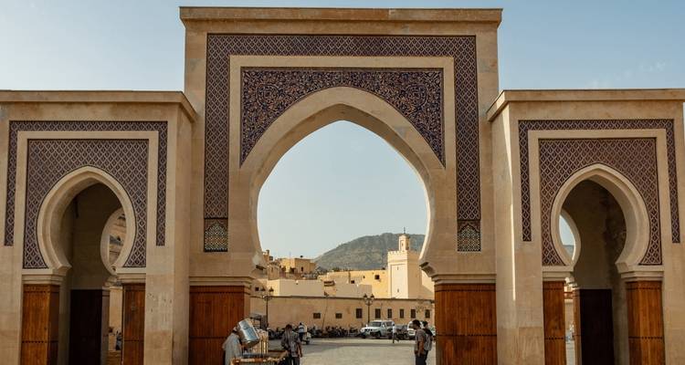 Ornate city gate with a view of an old city.