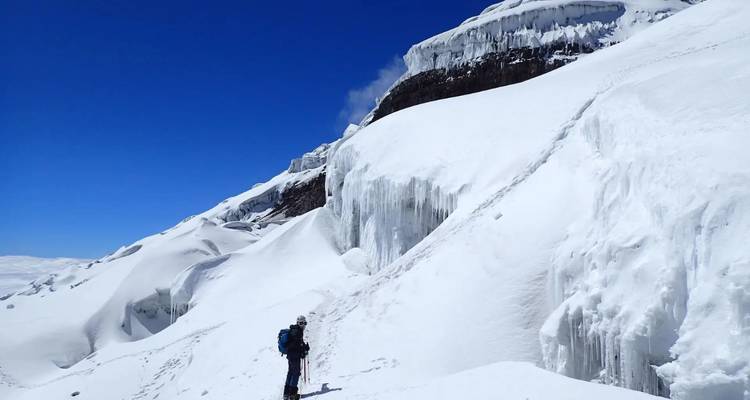 Personne escaladant une montagne couverte de neige.