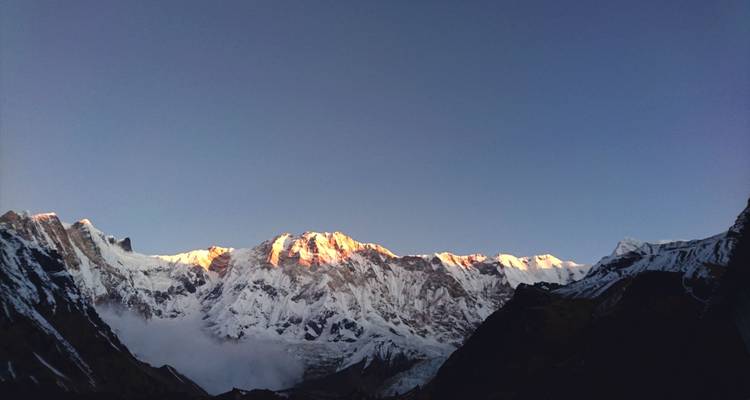 Panoramic view of snow-capped mountains at sunrise.