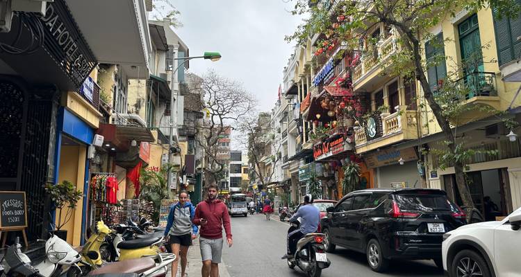 Belebte Straßenszene mit Geschäften und Fußgängern in städtischer Umgebung.