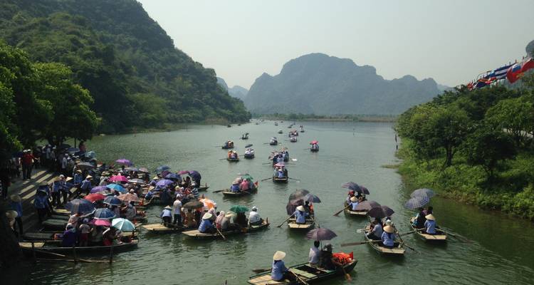 Touristen in kleinen Booten paddeln auf einem malerischen Fluss.