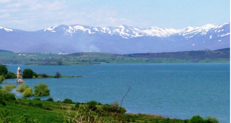 Lac avec montagnes environnantes sous un ciel dégagé.