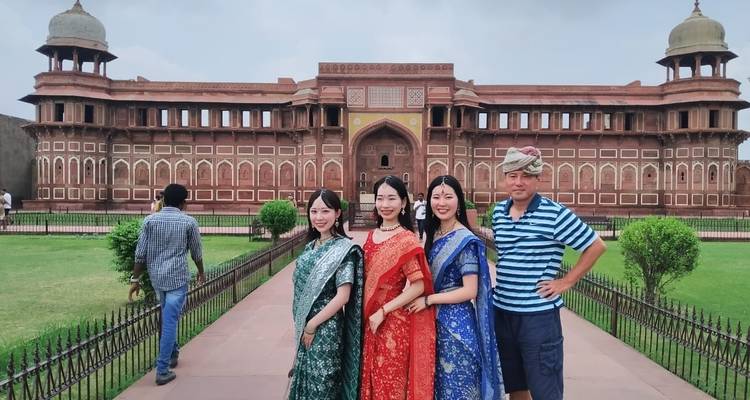 Groep in traditionele klederdracht voor een historisch gebouw.