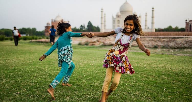Kinderen die spelen voor de Taj Mahal.