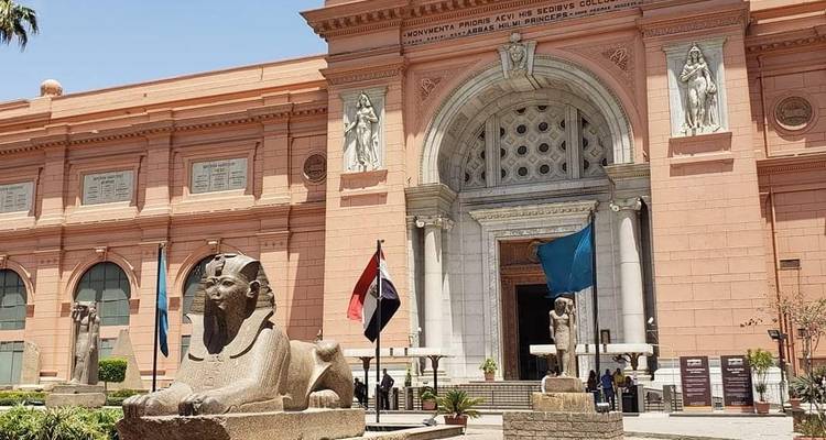 Outside view of the Egyptian Museum with sphinx statues and flags.
